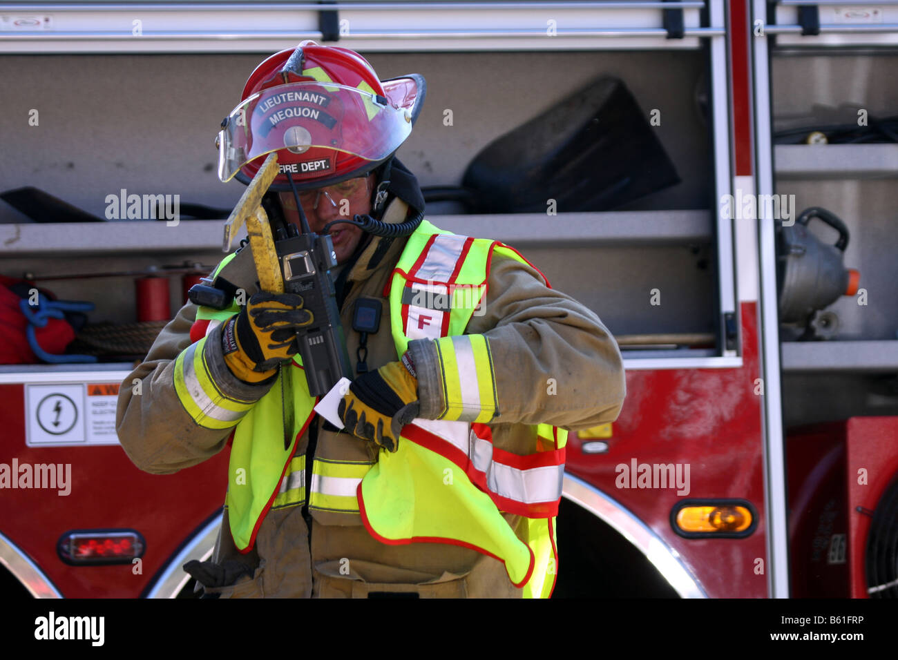 Mequon Fire Department Lieutenant putting his radio inside his coat Wisconsin Stock Photo