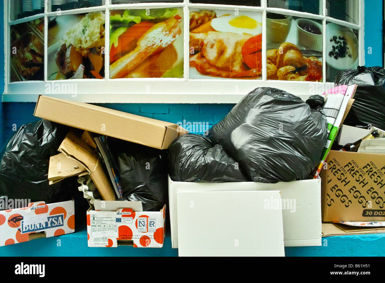 Piles of trash rubbish waste outside an English cafe in London England