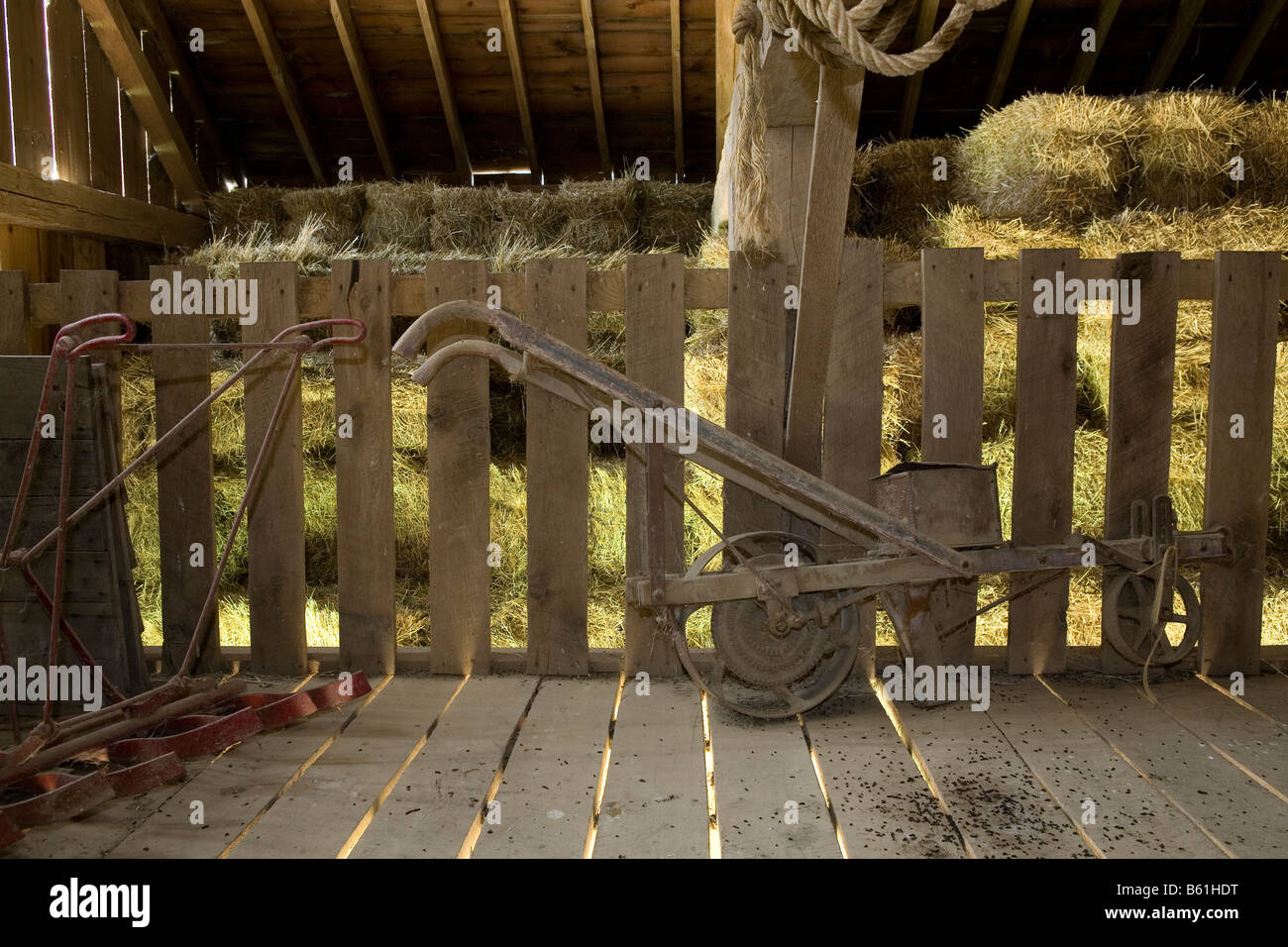 Old farm implements in store in a barn in a city park. Stock Photo