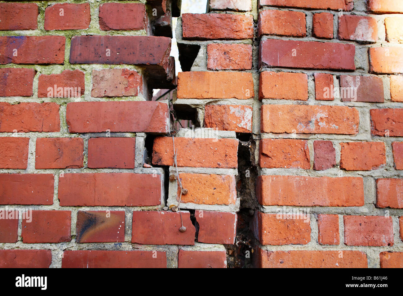 Broken bricks mortar wall subsidence maintenance old poor construction Stock Photo