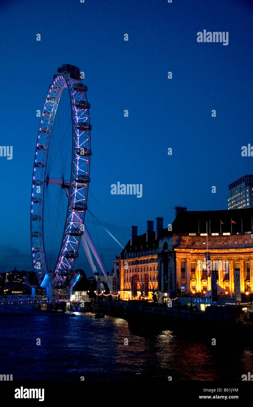 The London Eye at night along the River Thames in London England Stock Photo