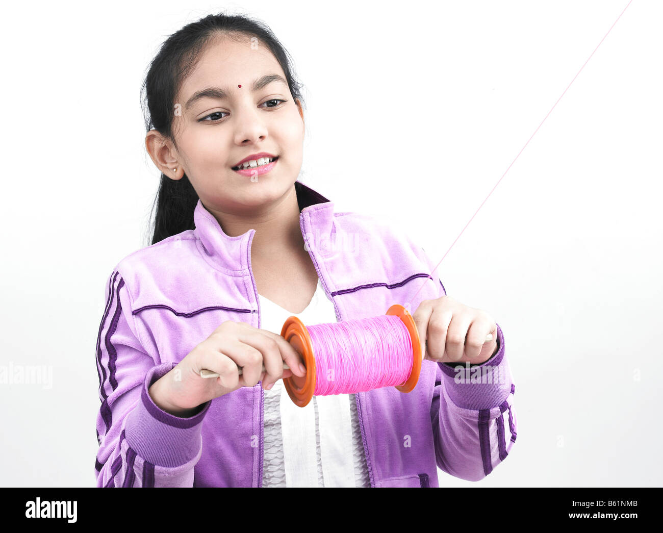 a smart asian girl of indian origin flying a kite Stock Photo