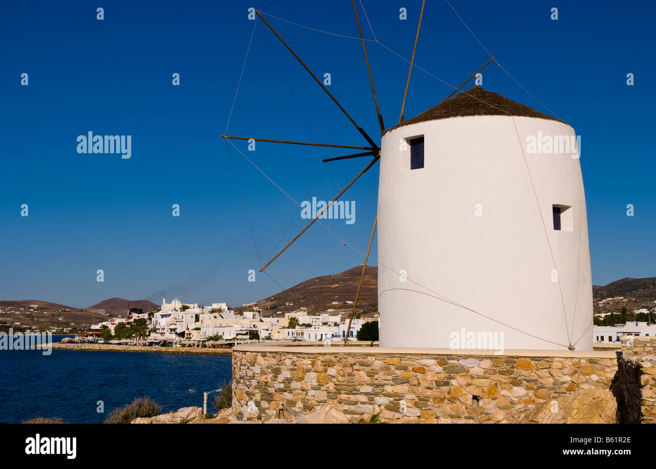 Famous windmill in harbor with center of city of Parikia capital city ...