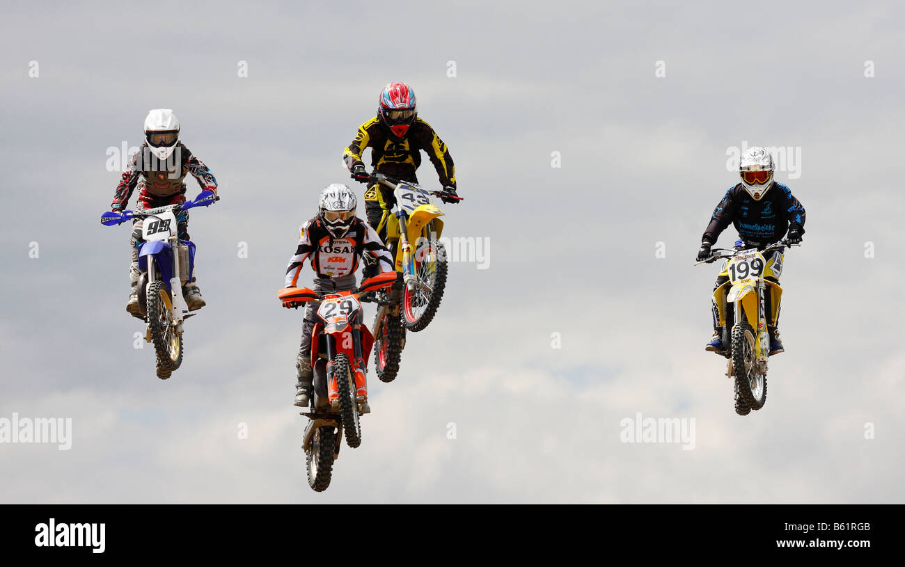 Four jumping motocross riders Stock Photo