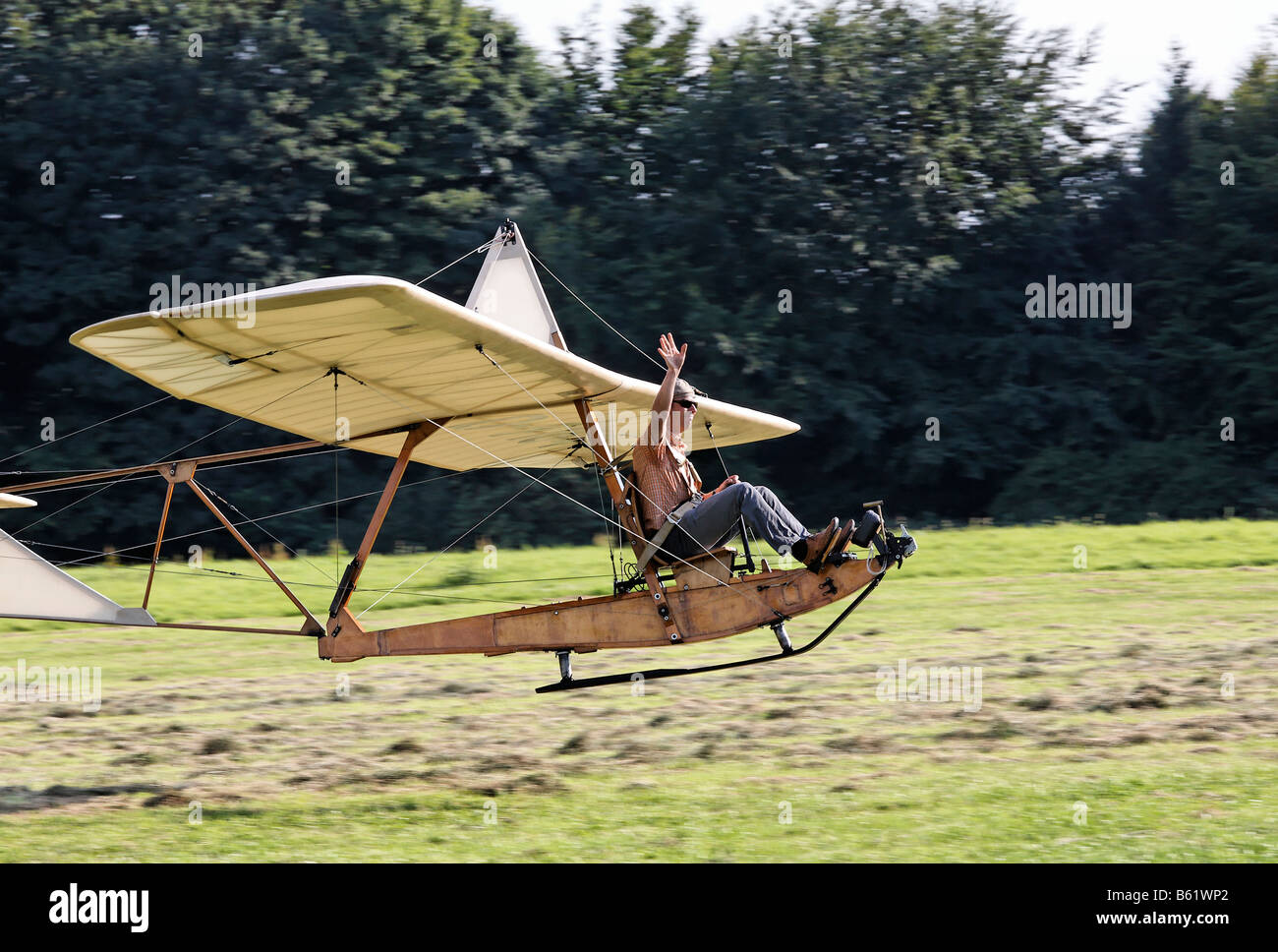 Pilot landing the historic glider SG38 on a field and waving to an audience, wooden construction with an open seat, glider to t Stock Photo