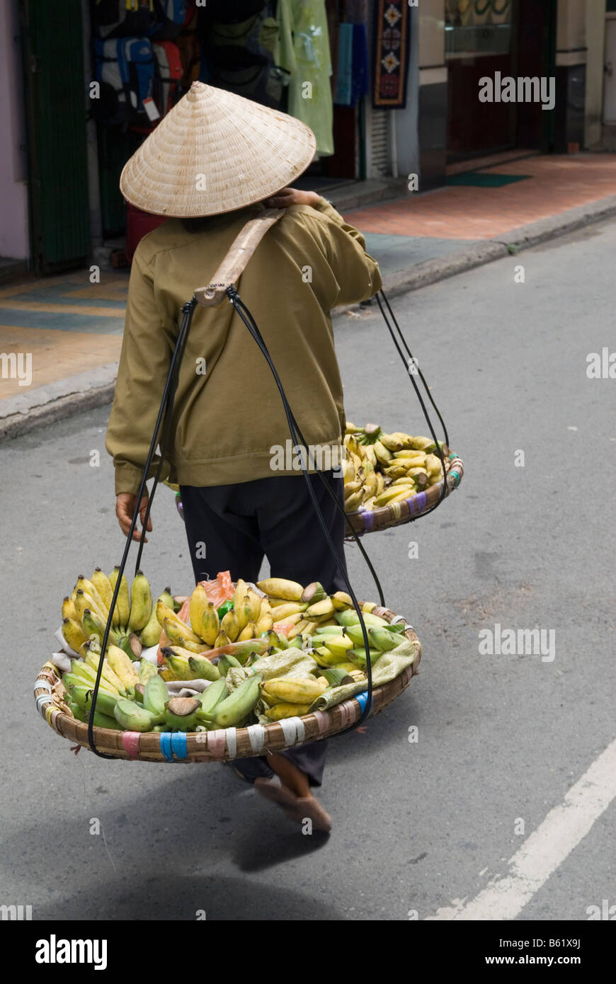Vietnamese street trader wearing a conical leaf hat, Ho Chi Minh City, Vietnam Stock Photo