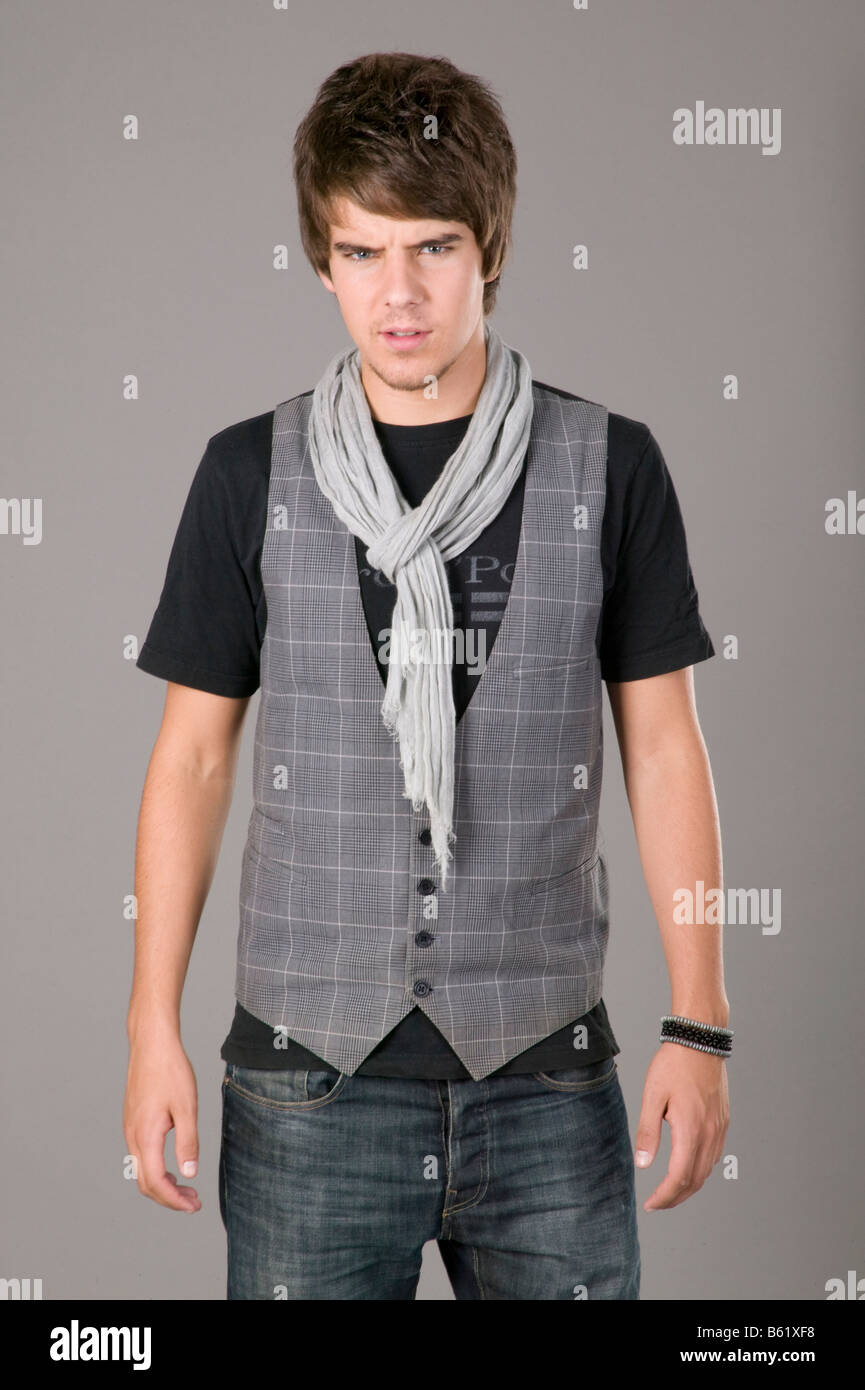 Young man standing in front of gray wall Stock Photo - Alamy