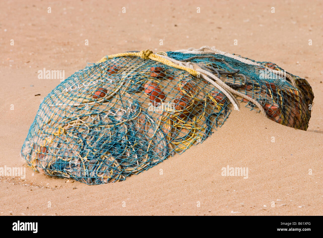 Commercial seine fishing net lying on beach sand at the Marina