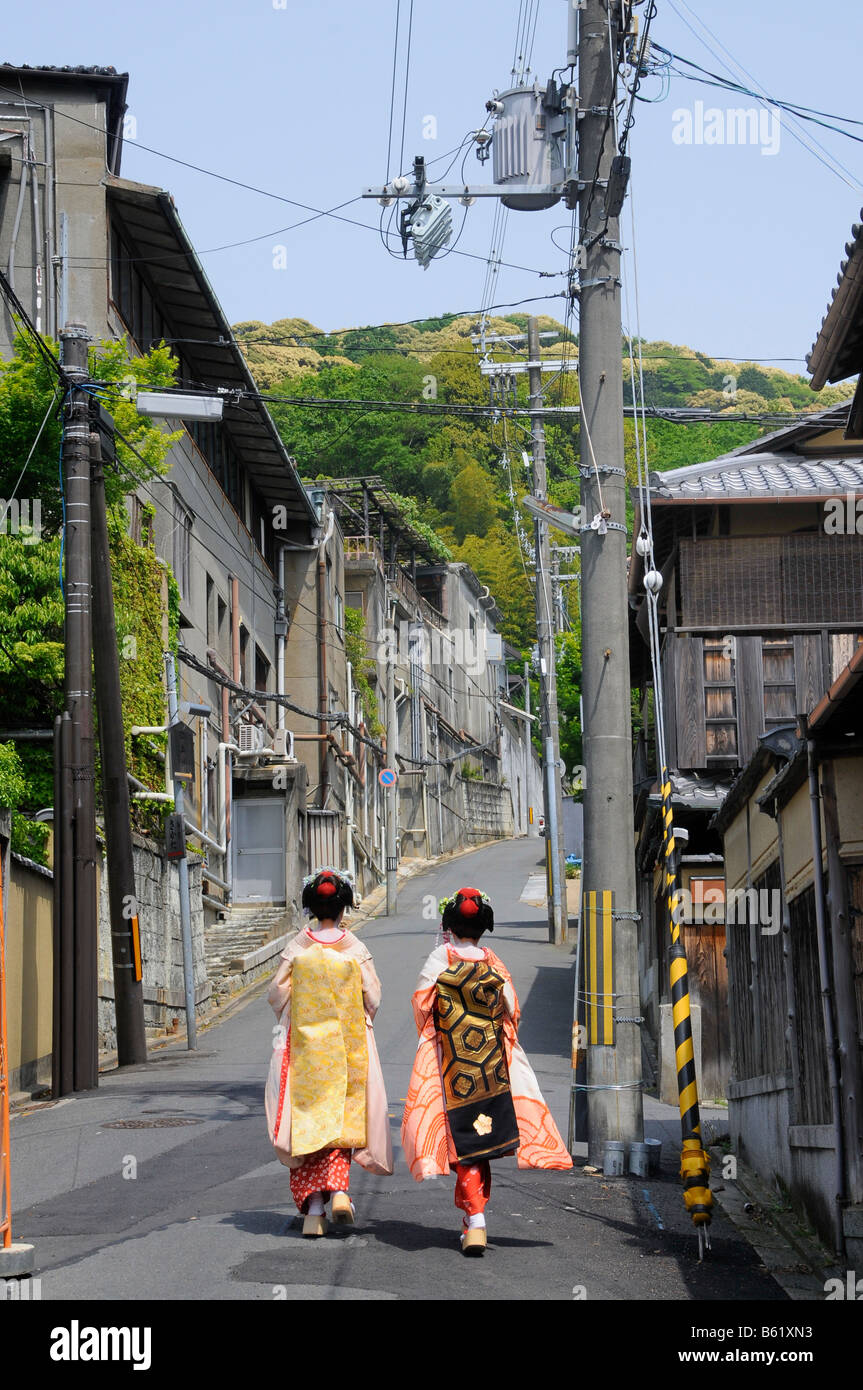 Maikos, apprentice Geishas, walking through a monotone street in Kyoto, Japan, Asia Stock Photo