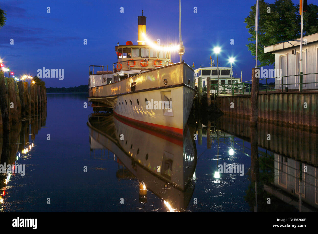 Night-time illuminated pleasure paddle steamer "Ludwig Fessler" in Prien harbour, Lake Chiemsee, Chiemgau, Upper Bavaria, Germa Stock Photo