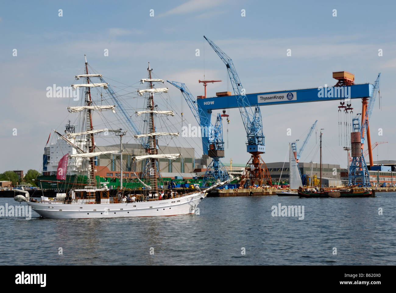 Traditional sailing boats in front of the crane of the Howaldtswerke-German-Shipyard, HDW, in the Kiel inner Fjord, Kiel Week 2 Stock Photo