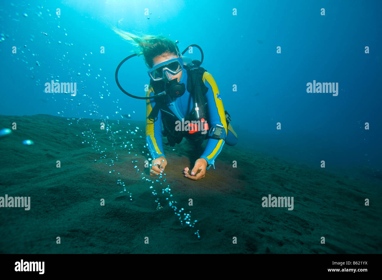 Scuba diver observing volcanic gas bubbles, rising from the hot sea