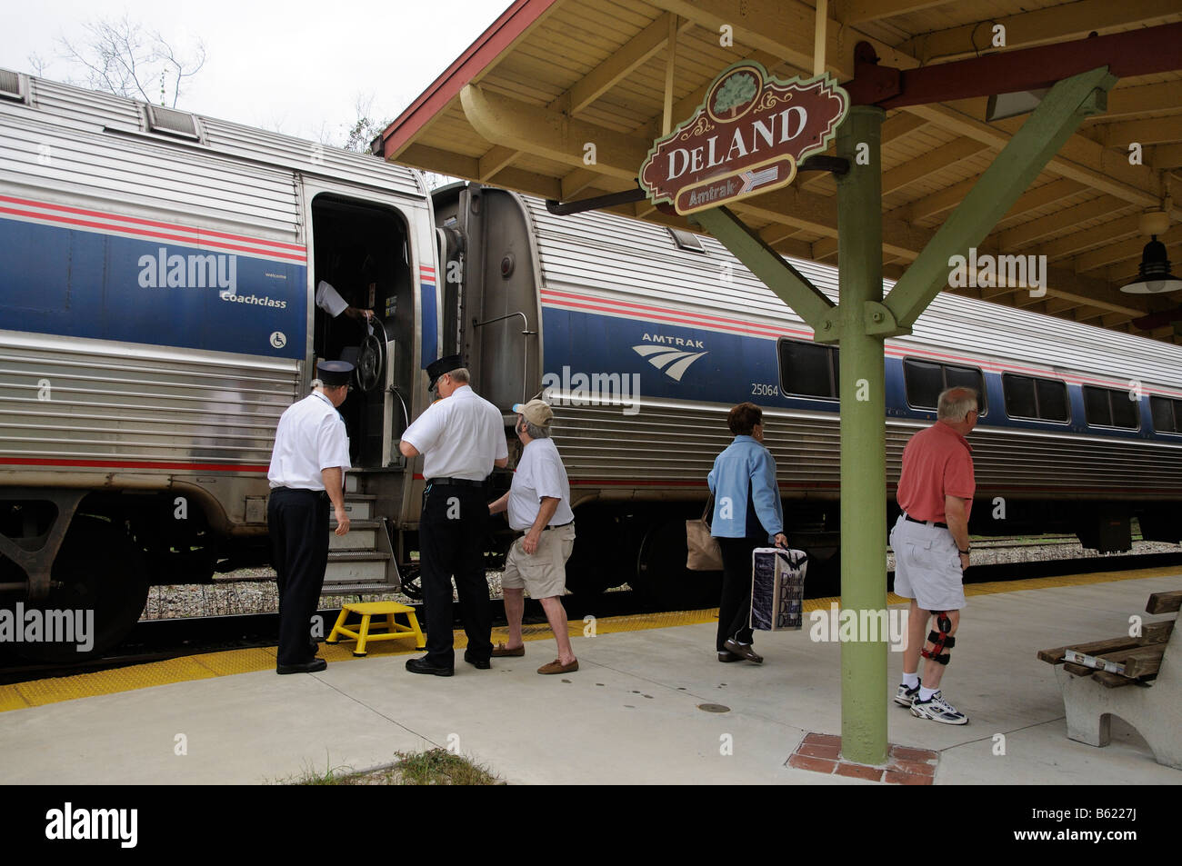 Amtrak railroad conductors assisting passengers onto train DeLand Train