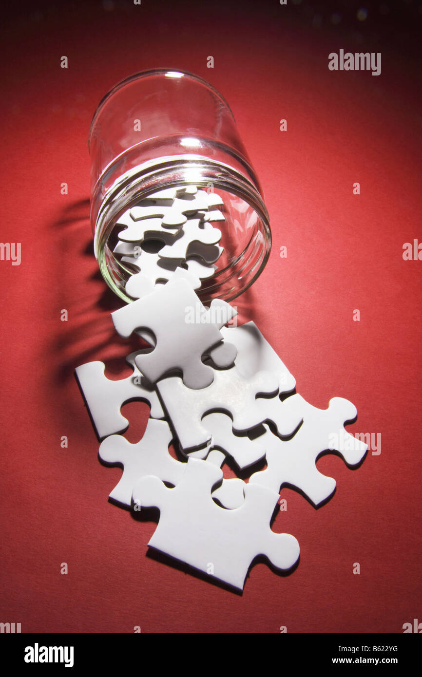 Jigsaw Puzzle Pieces Spilling From Glass Jar Stock Photo