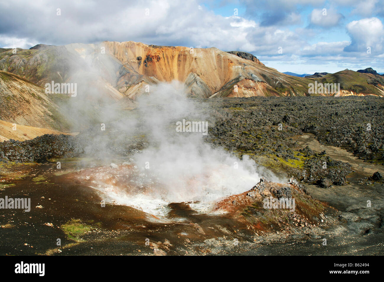 Hot and steaming springs, fumaroles, in the lava fields in front of the colourful Rhyolith Mountains of Landmannalaugar, Icelan Stock Photo
