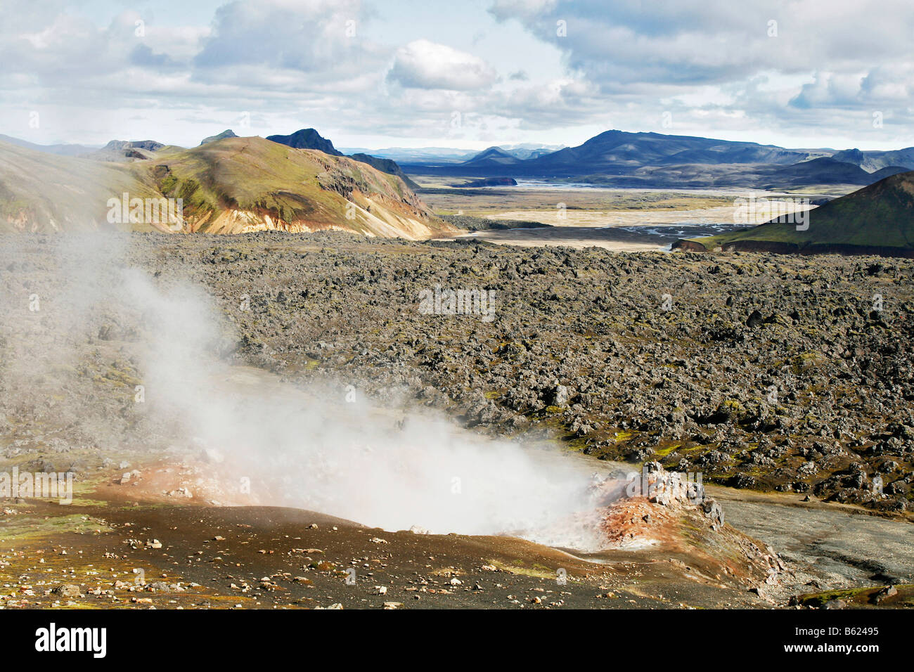 Hot and steaming springs, fumaroles, in the lava fields in front of the colourful Rhyolith Mountains of Landmannalaugar, Icelan Stock Photo