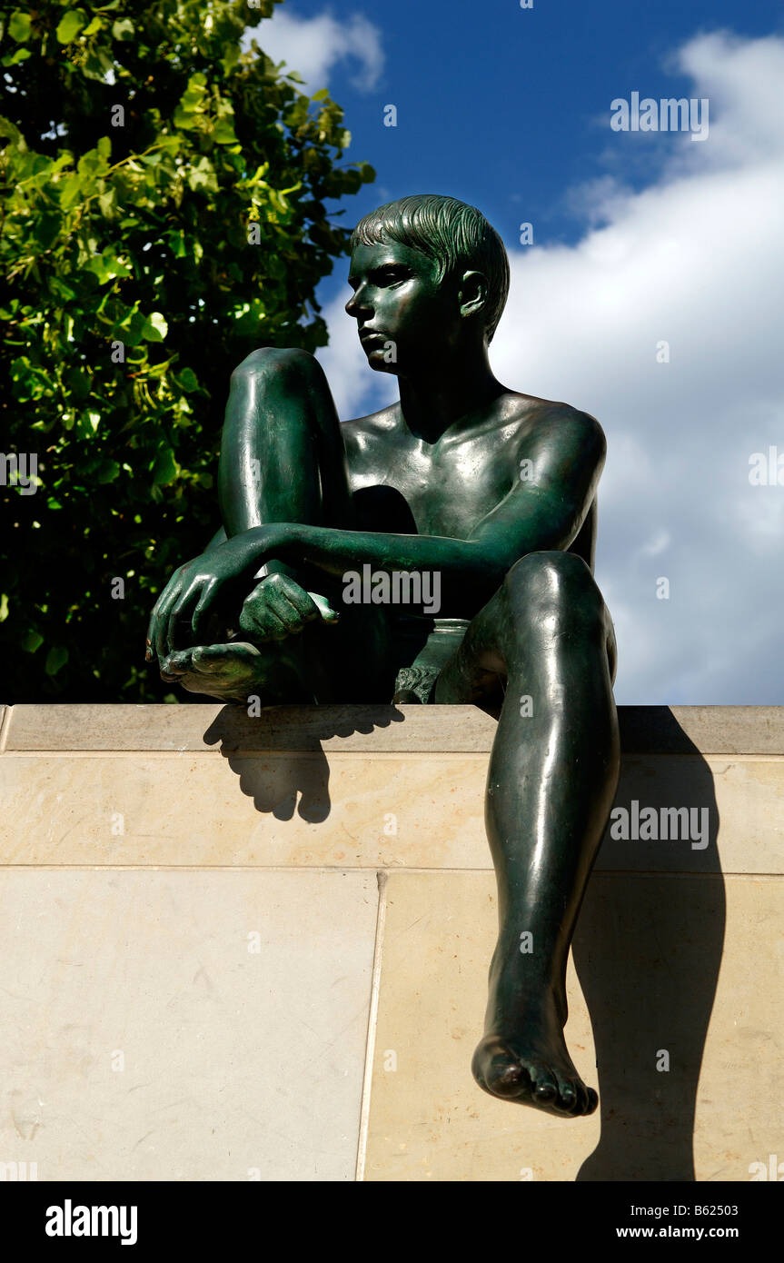 Sculpture of a boy sitting on a wall, Berlin, Germany, Europe Stock Photo