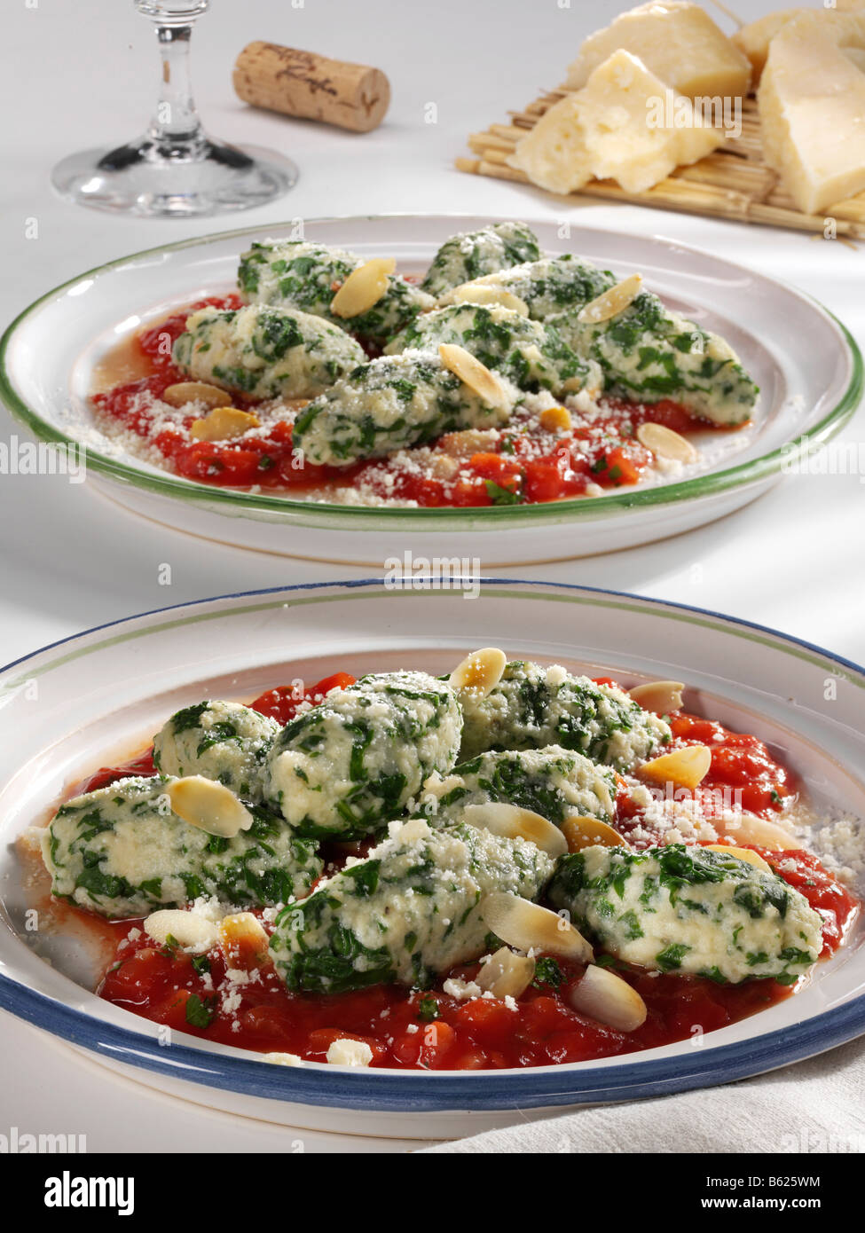 Spinach Gnocche with tomato sauce on plates Stock Photo