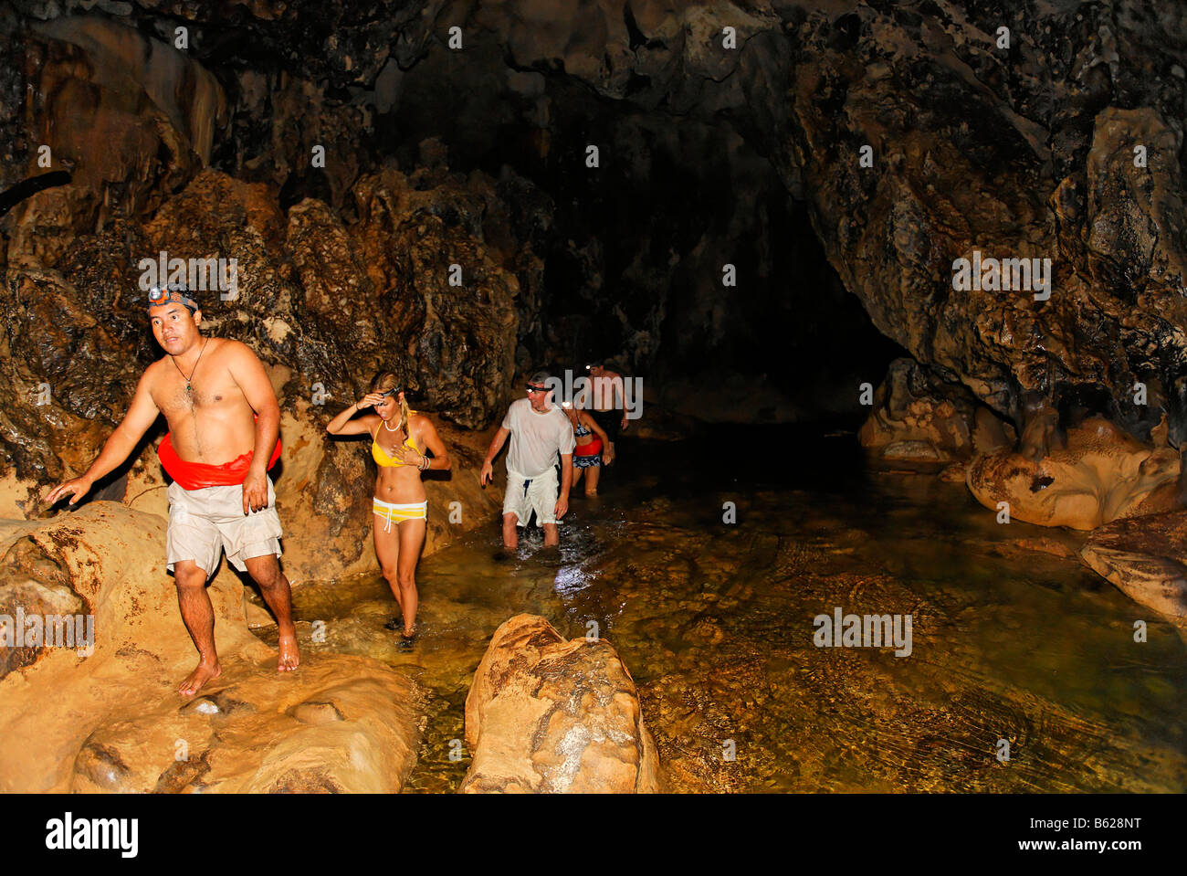 Tourists with a Mayan guide swimming and walking investigating a cave with a warm water course, Punta Gorda, Belize, Central Am Stock Photo