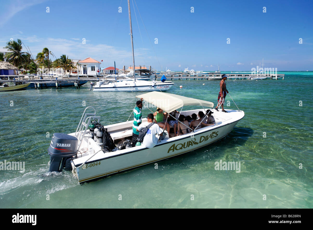 Diving boat loaded with scuba divers heads out to sea, San Pedro, Ambergris Cay Island, Belize, Central America, Caribbean Stock Photo