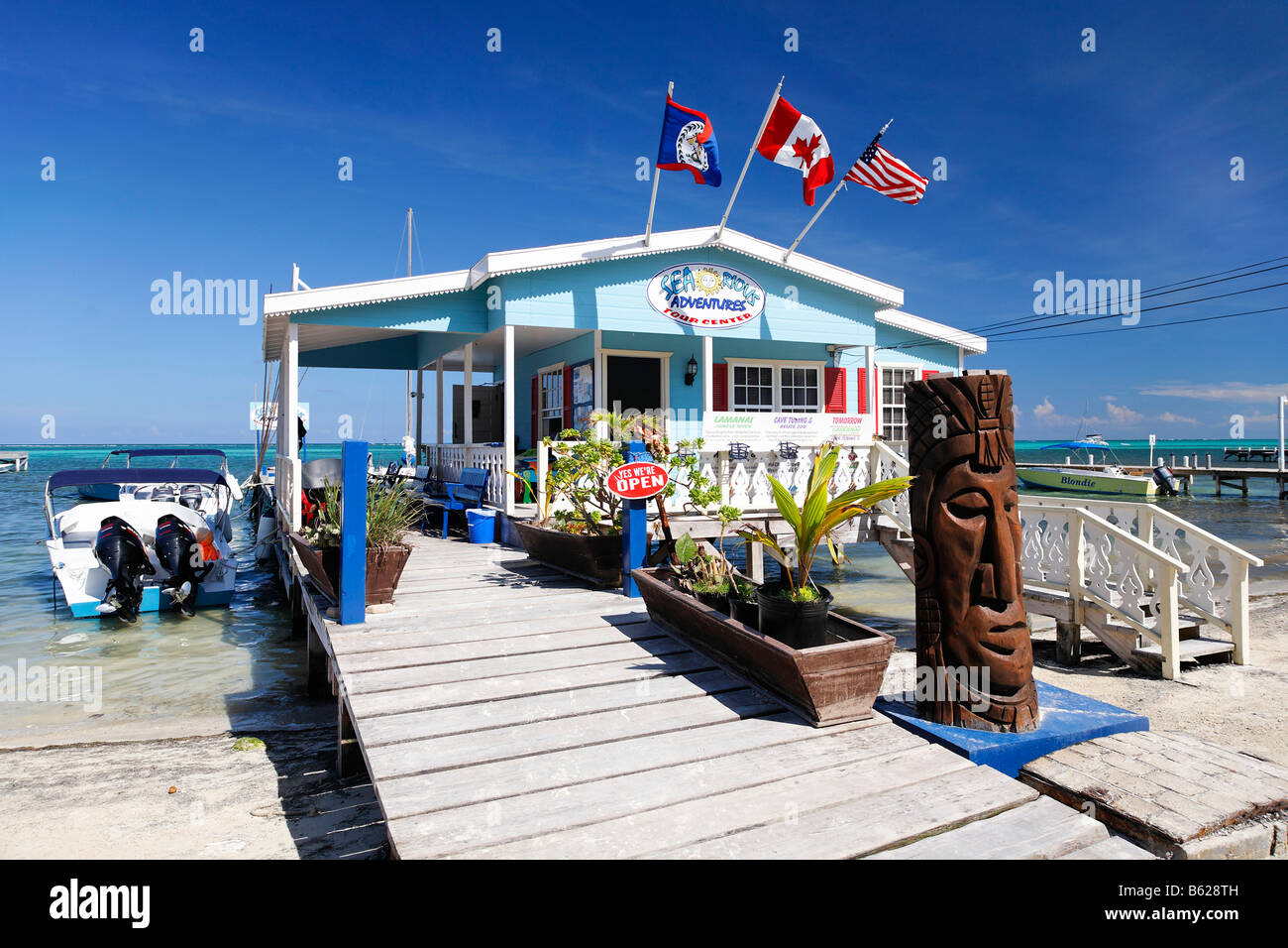 Carved wooden face in front of a restaurant on a pier in the ocean of San Pedro, Ambergris Cay Island, Belize, Central America, Stock Photo