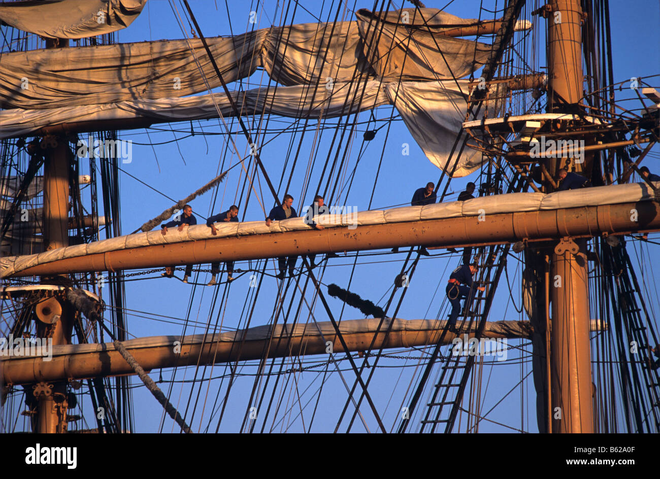 Russian sailors manipulate the sails & rigging of the Russian tall ship 'Sedov' during a stop-over in Marseille harbour, France Stock Photo