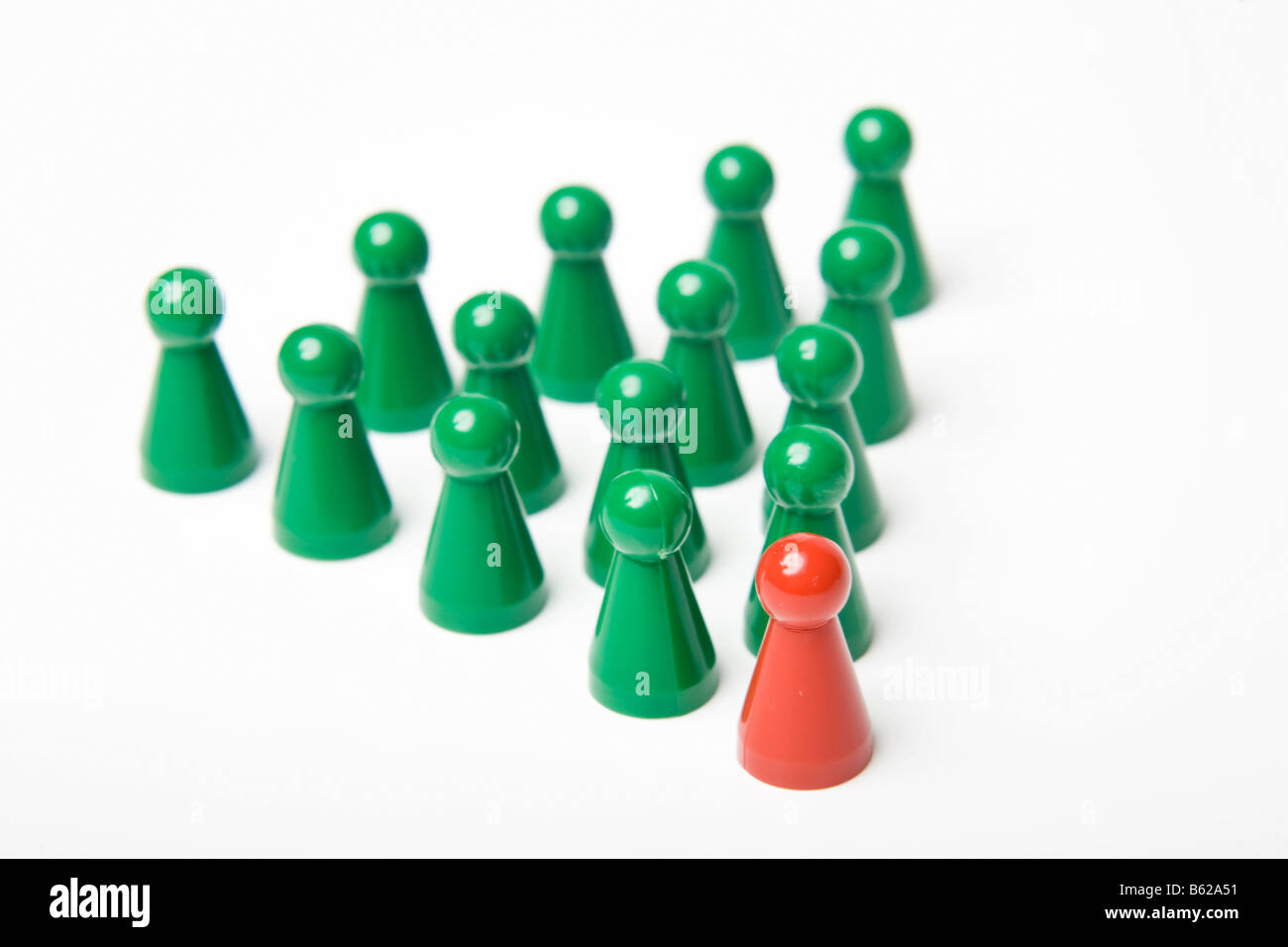 Green gaming pieces standing behind a single red gaming piece, symbolic of leadership Stock Photo