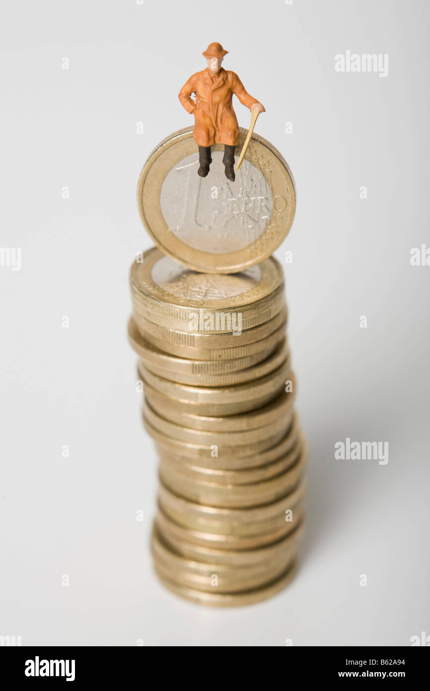 Pensioner figure sitting on a pile of euro coins, symbolic for retirement Stock Photo