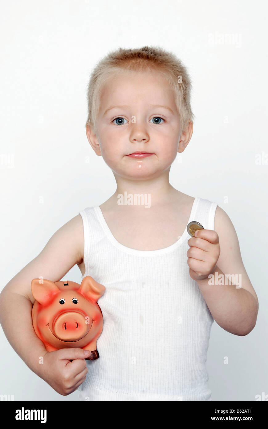 Boy with a piggy bank and coins Stock Photo