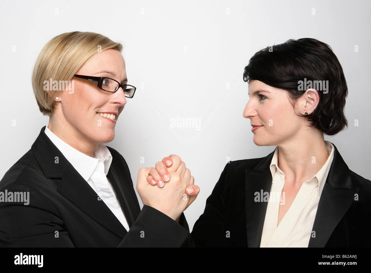 Two confident looking women shaking hands Stock Photo