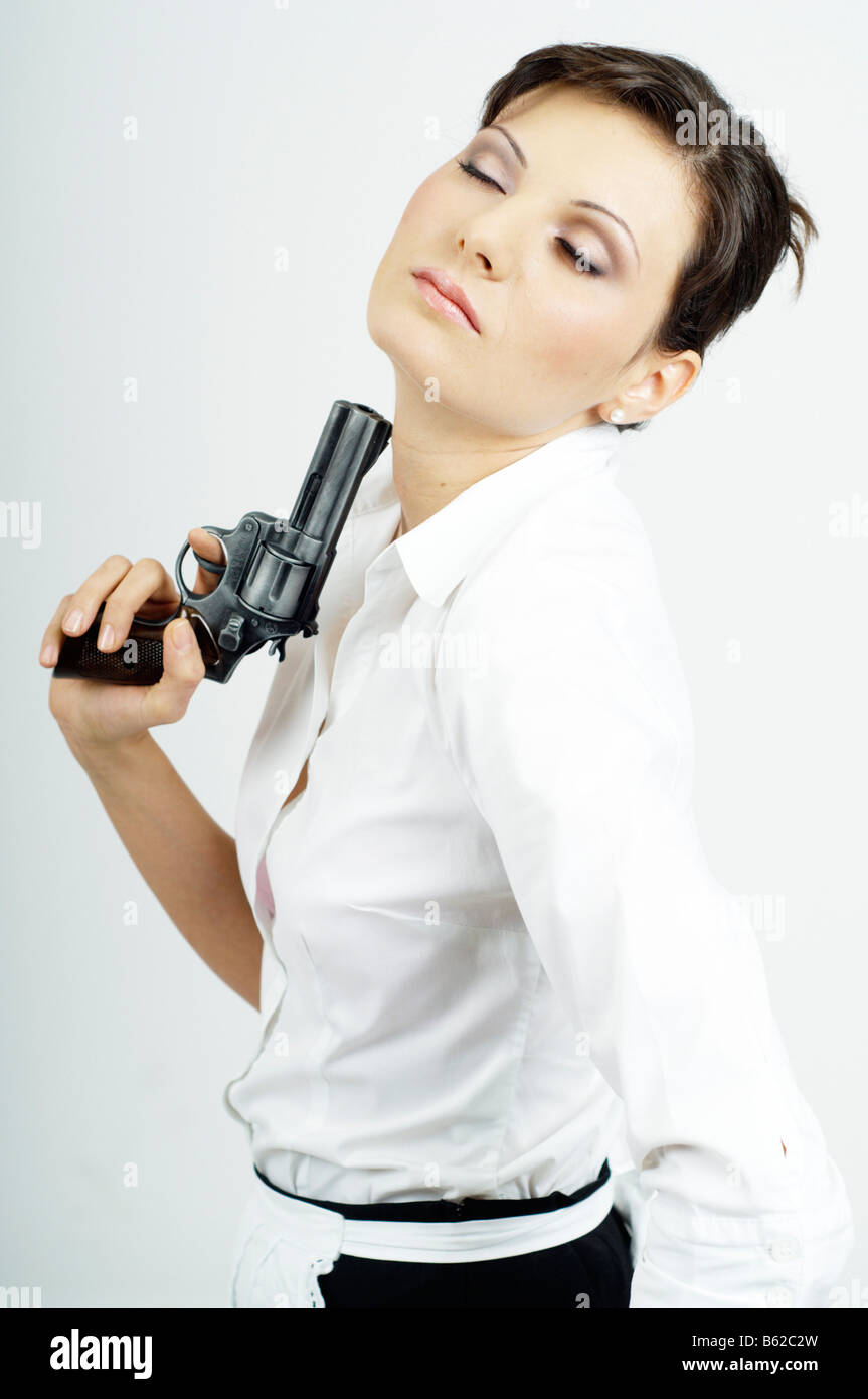 Young woman dressed as server playing with a gun Stock Photo