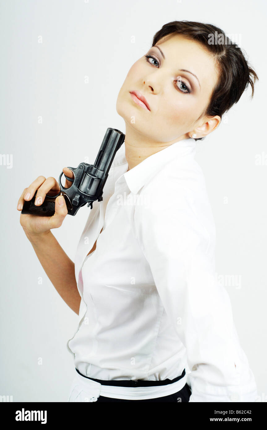 Young woman dressed as a waitress holding a gun Stock Photo