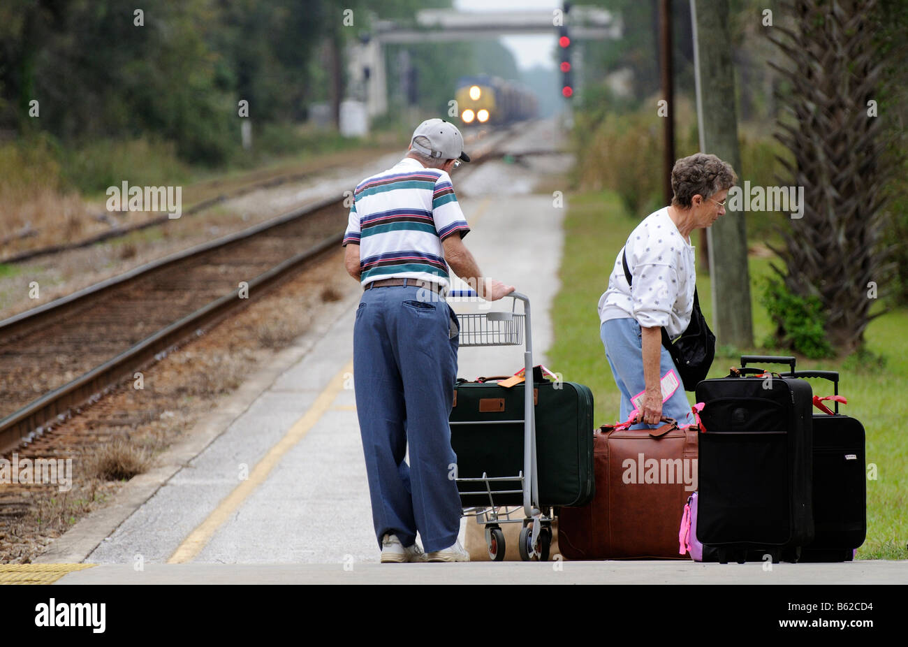 Railroad passengers with luggage trolley and bagage on railroad station