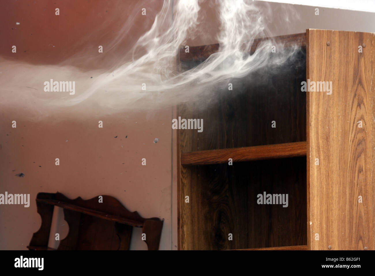 The smoke wafting out of a container full of furniture There is ash debris in the air Stock Photo