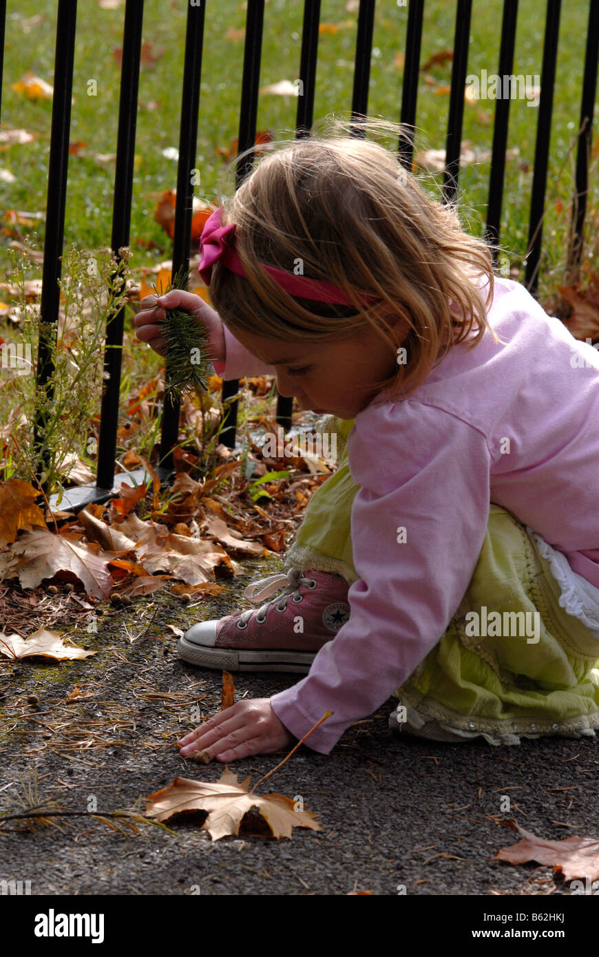 Little girl playing with autumn leaves in a park Stock Photo - Alamy