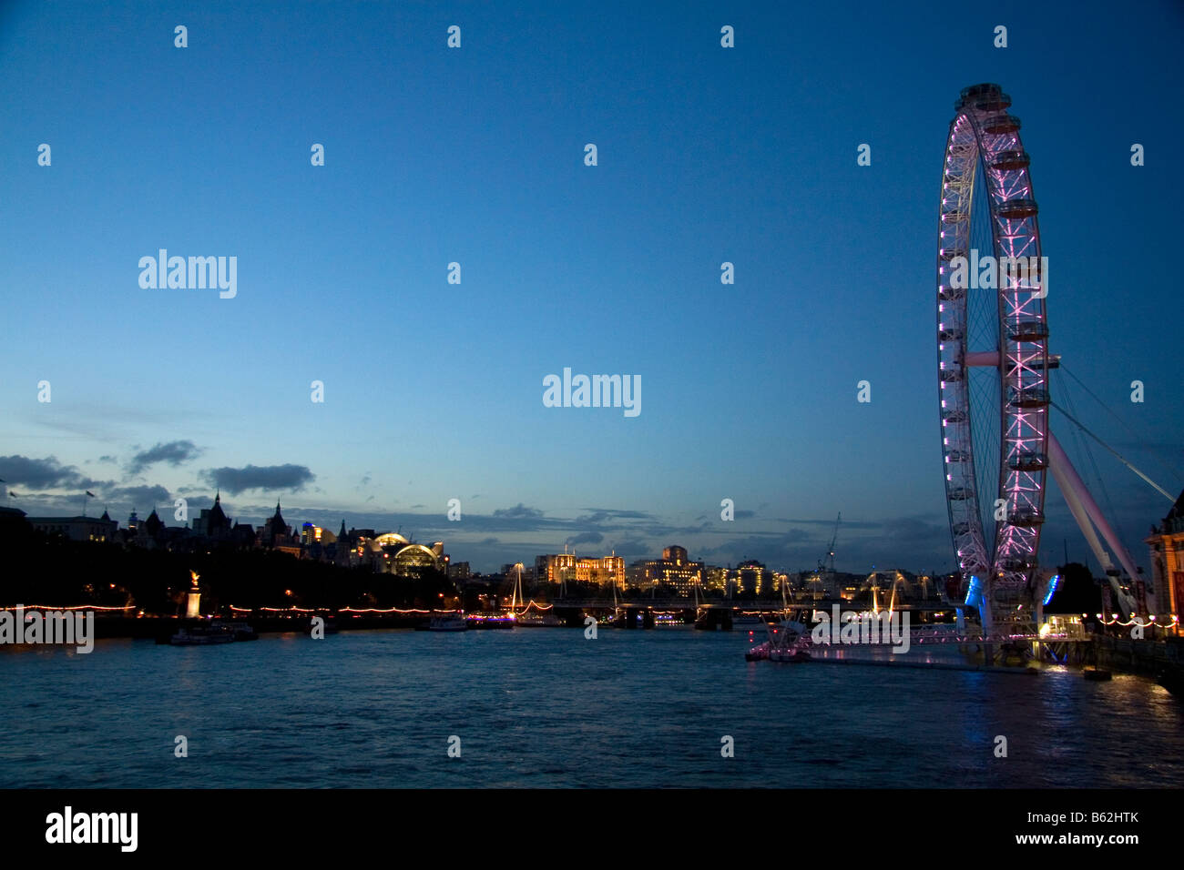 The London Eye at night along the River Thames in London England Stock Photo