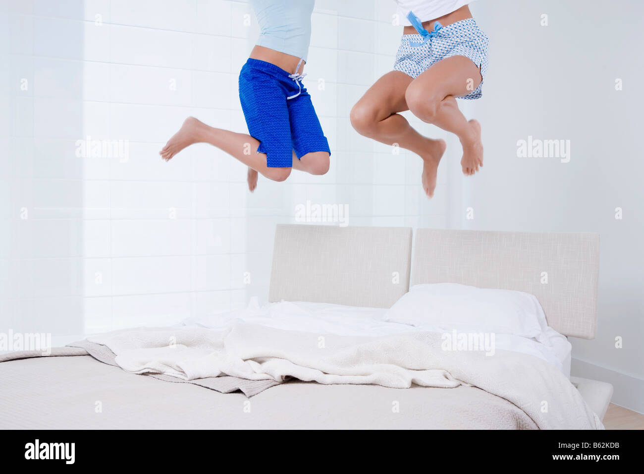 Two people jumping on the bed Stock Photo Alamy