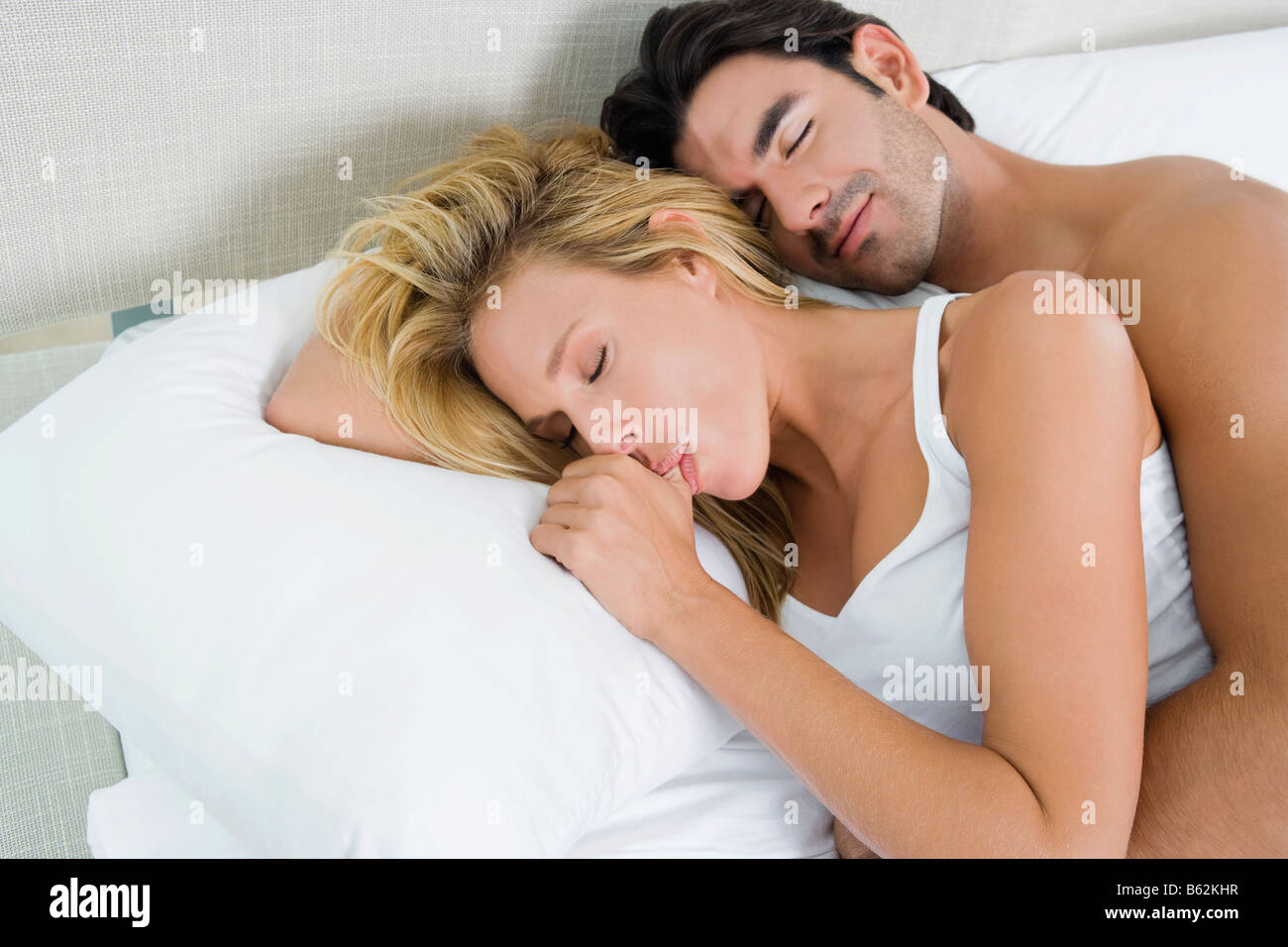 High angle view of a young man and a mid adult woman lying on the bed Stock Photo
