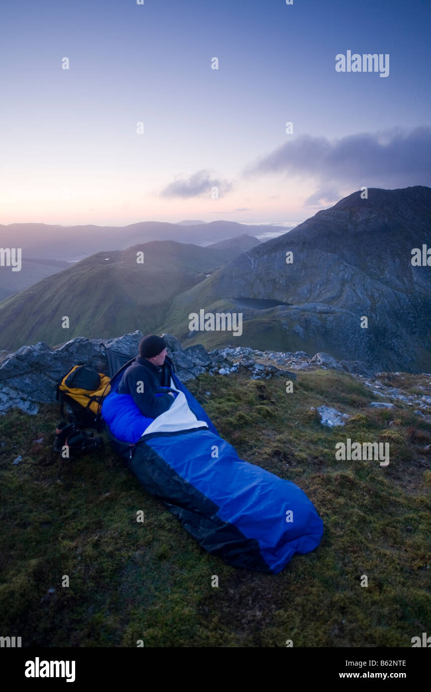 Hiker bivouac at  the summit of Knocknahillion mountain, Maumturk Mountains, Connemara, County Galway, Ireland. Stock Photo