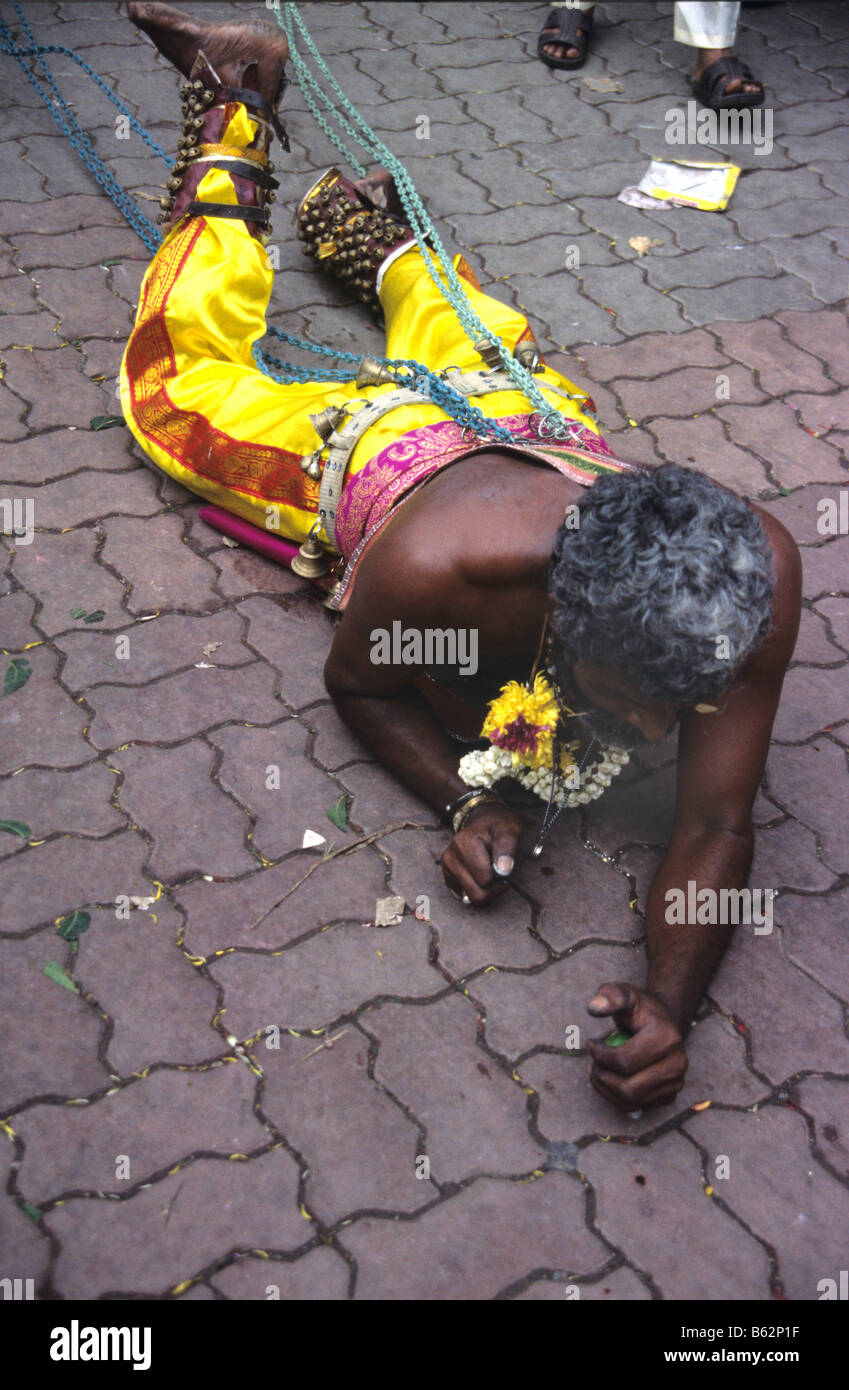 A Hindu penitent crawls towards the Batu Caves during the annual Thaipusam Festival at Batu Caves, Kuala Lumpur, Malaysia Stock Photo