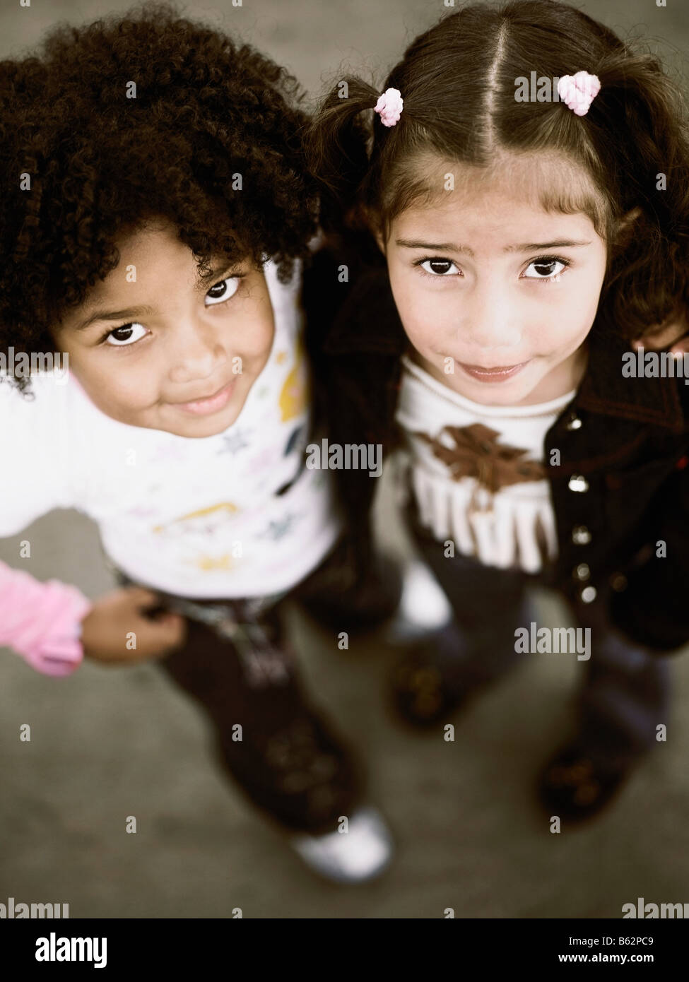 Portrait of two girls standing with their arms around each other Stock ...