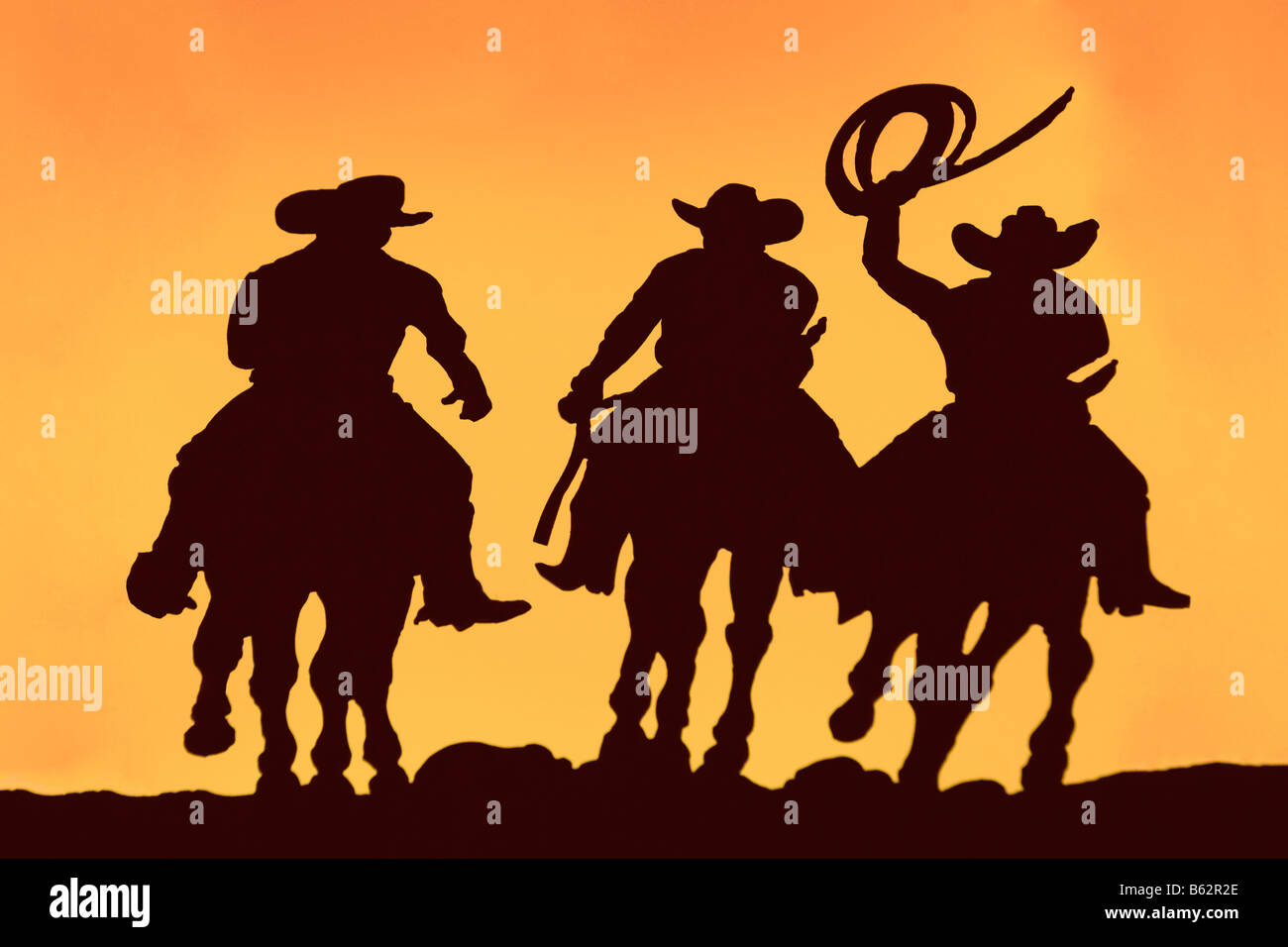 Silhouette of three men horseback riding Stock Photo