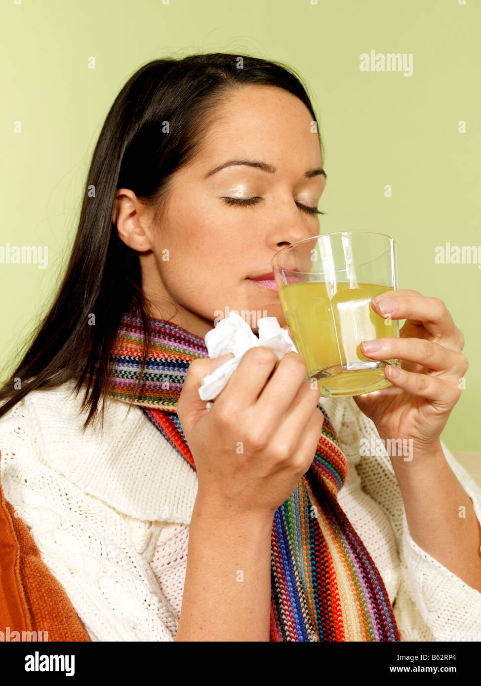 Young Woman Suffering From A Winter Cold Or Flu Taking A Glass Of