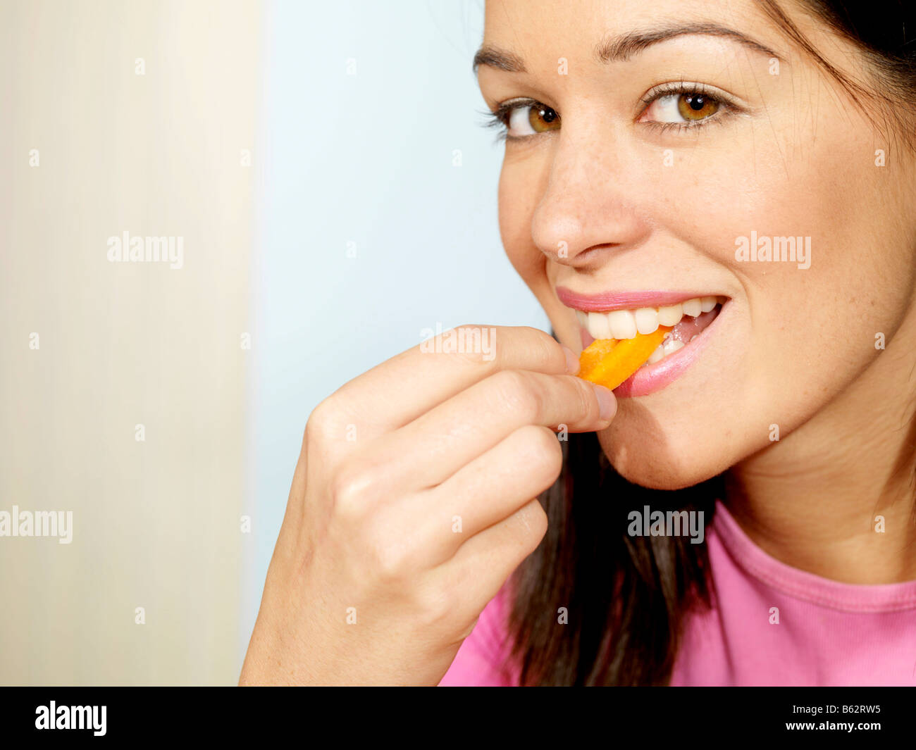 Young Woman Eating Carrot Sticks Model Released Stock Photo