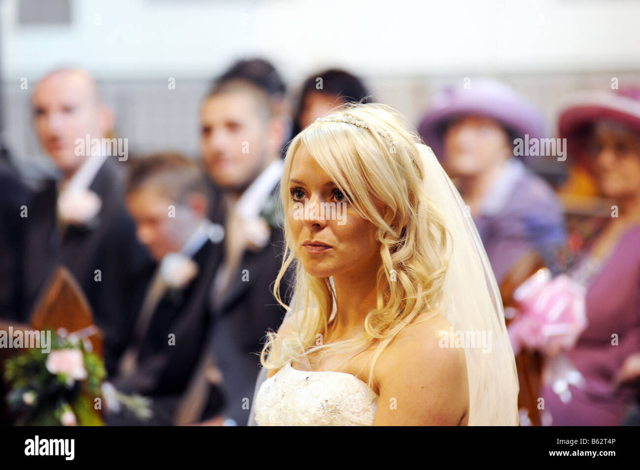 A bride sits at the front of the church before getting married Stock Photo