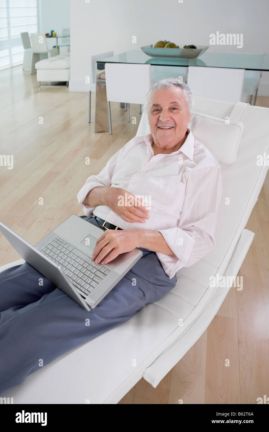 High angle view of a senior man using a laptop and smiling Stock Photo