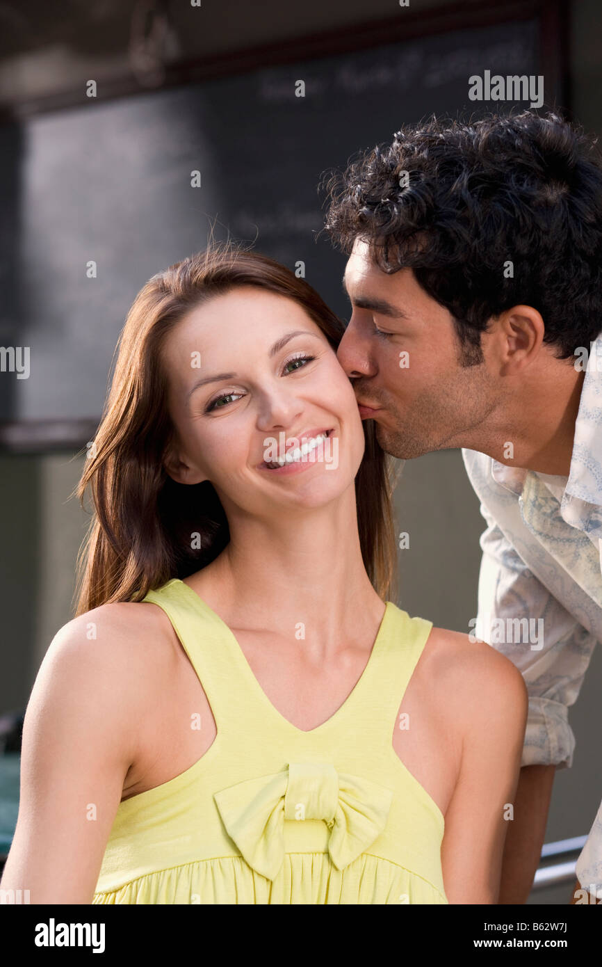 Side profile of a young man kissing a young woman Stock Photo - Alamy