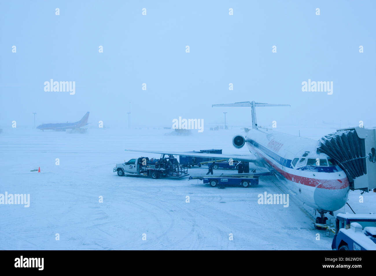USA Colorado Passenger jet on runway during winter snowstorm at Denver International Airport Stock Photo