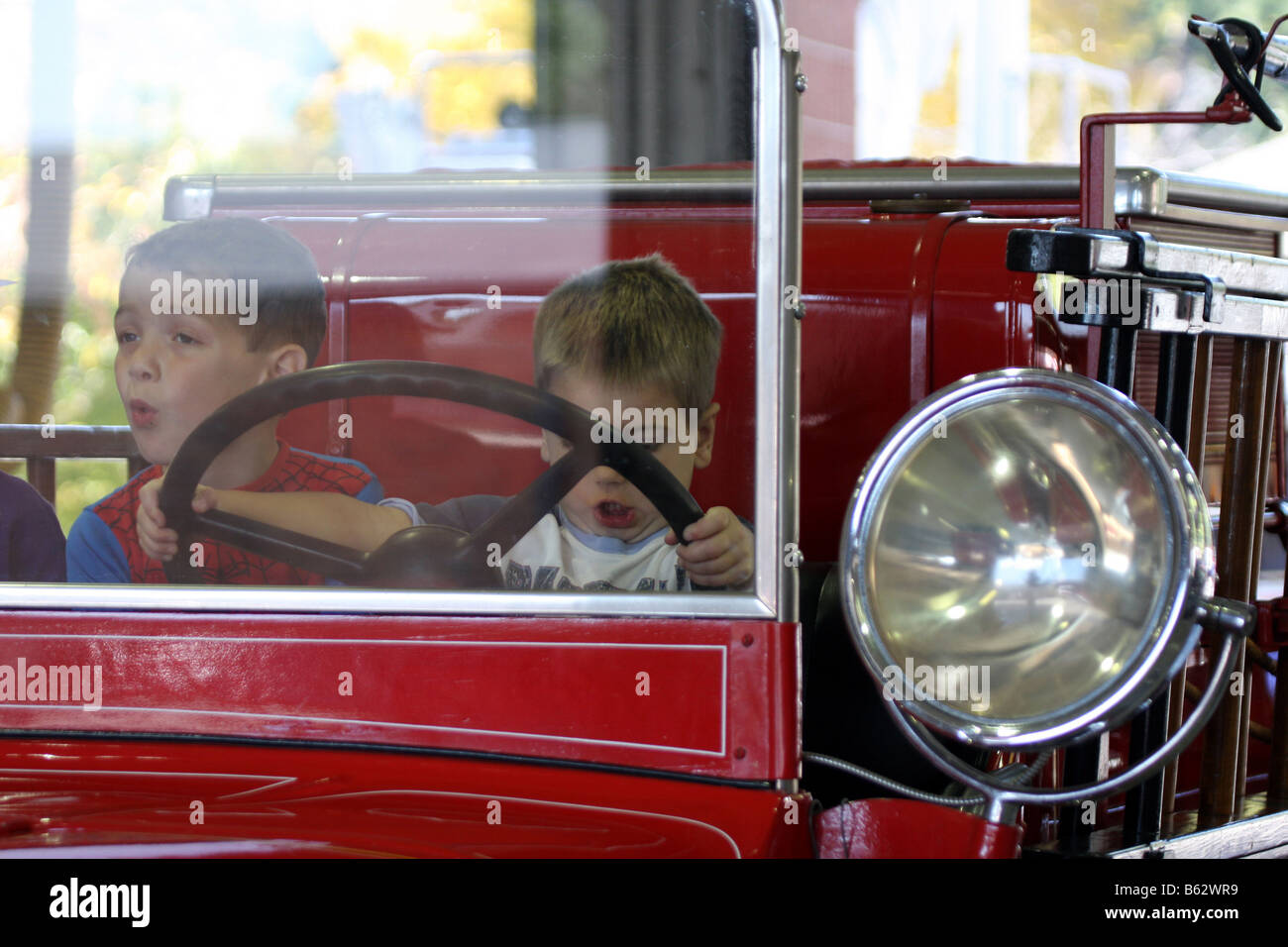 Kids enjoying pretend driving a 1933 Pirsch Sterling Fire Engine at a Fire Safety Fair Town of Mequon Wisconsin Stock Photo