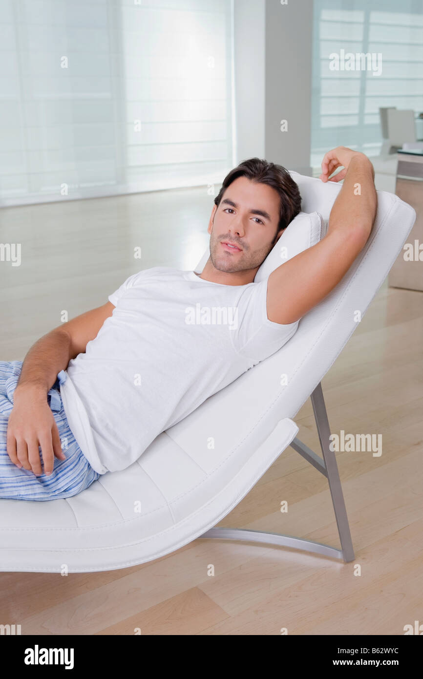 Young man resting on a reclining chair Stock Photo Alamy